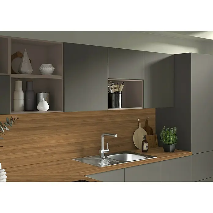 CUCINE Küchenrückwand Fixmaß - Nancy Nussbaum/Arosa Eiche, 410 x 64 cm, Stärke: 9,2 mm - Nahaufnahme einer modernen Küchenspüle mit Armatur, umgeben von einer Arbeitsplatte in Holzoptik und grauen Schränken.