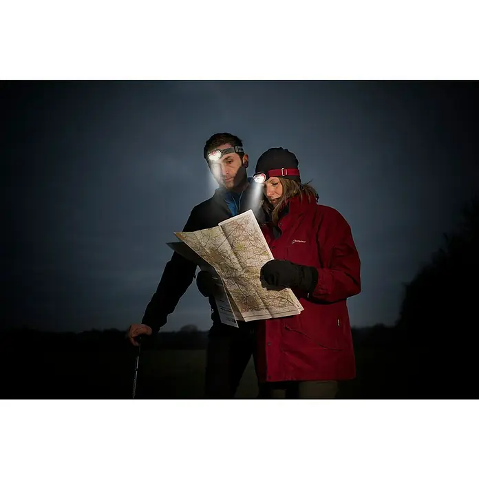 Energizer Linterna frontal - 4 x 4,5 x 7,3 cm, 300 lm, IPX4 - Dos personas con linternas frontales miran un mapa en la oscuridad. Perfecto para aventuras al aire libre y exploración nocturna.