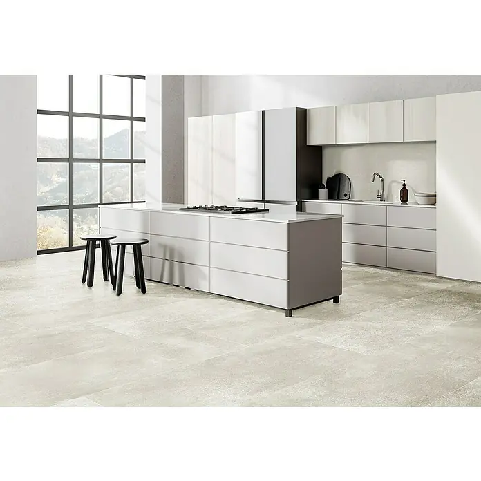 Feinsteinzeugfliese Rimini - 60 x 120 cm, Bianco, Matt - Helle Küche mit Kochinsel, minimalistischem Design und zwei schwarzen Hockern. Fokus auf die hochwertige Küchenausstattung und das moderne Ambiente.