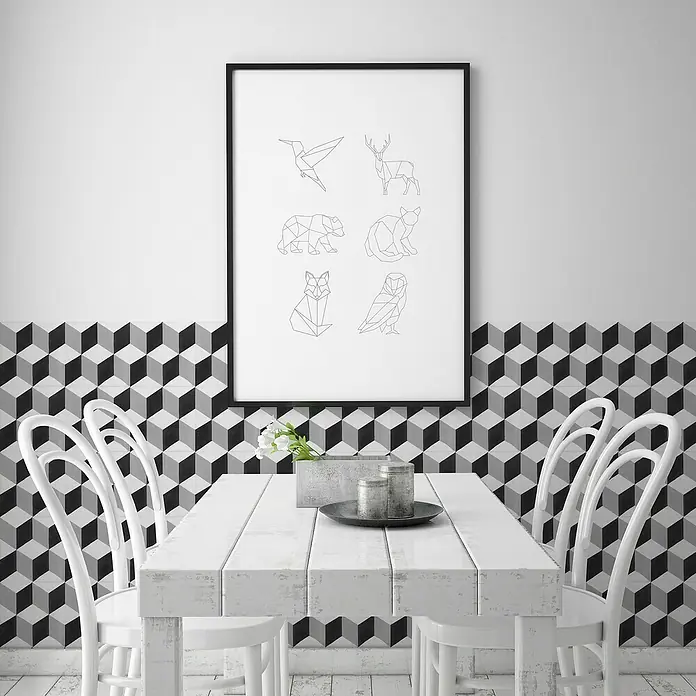Feinsteinzeugfliese Barcelona Cube - 24,8 x 24,8 cm, Weiß/Schwarz/Grau, Matt - Ein minimalistisches Poster mit geometrischen Tierzeichnungen hängt über einem Esstisch, umgeben von stilvollen weißen Stühlen.