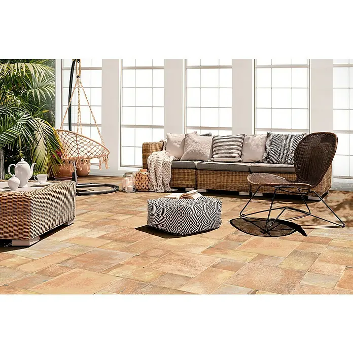 Feinsteinzeugfliese Caeser - 50 x 50 cm, Rotbraun, Matt - Einladende Terrasse mit Rattansofa, Hängesessel und gemustertem Hocker, ideal für entspannte Stunden im Freien mit stilvollem, wohnlichem Flair.