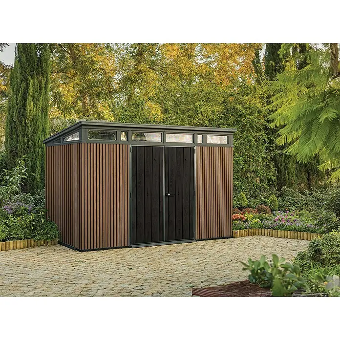 Keter Caseta para jardín Venetian Pent 11x7 - Medidas ext. (An x Pr): 340 x 218 cm, Plástico, Marrón/Antracita, 7,4 m² - Caseta de jardín moderna con paneles verticales de madera, puerta doble y claraboyas de cristal, en un entorno verde exuberante.