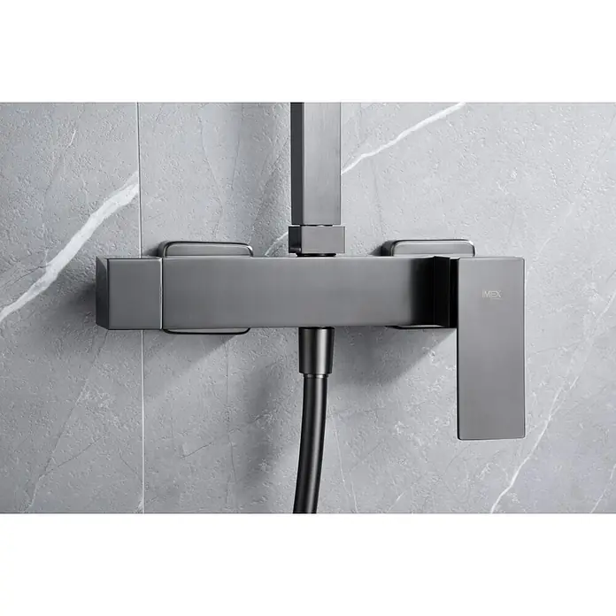 Imex Pisa Sistema de ducha - Grifo monomando, Black gun - Primer plano de un grifo de ducha IMEX gris montado en una pared de mármol.