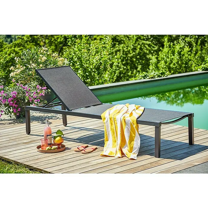 Sunfun Maja Gartenliege Design - Metall, Anthrazit, Rückenlehne verstellbar - Eine moderne Sonnenliege aus Metall mit einer gelb-weiß gestreiften Strandtuch auf einer Holzterrasse.