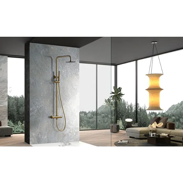 Imex Génova Sistema de ducha - Grifo termostático, Oro - Elegante conjunto de ducha dorado sobre pared de hormigón, prometiendo una experiencia de baño lujosa y moderna.
