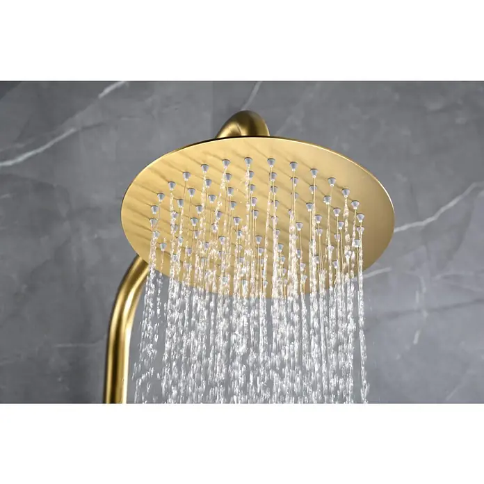 Imex Génova Sistema de ducha - Grifo termostático, Oro - Primer plano de un cabezal de ducha de lluvia dorado que libera chorros de agua contra un fondo gris marmolado.