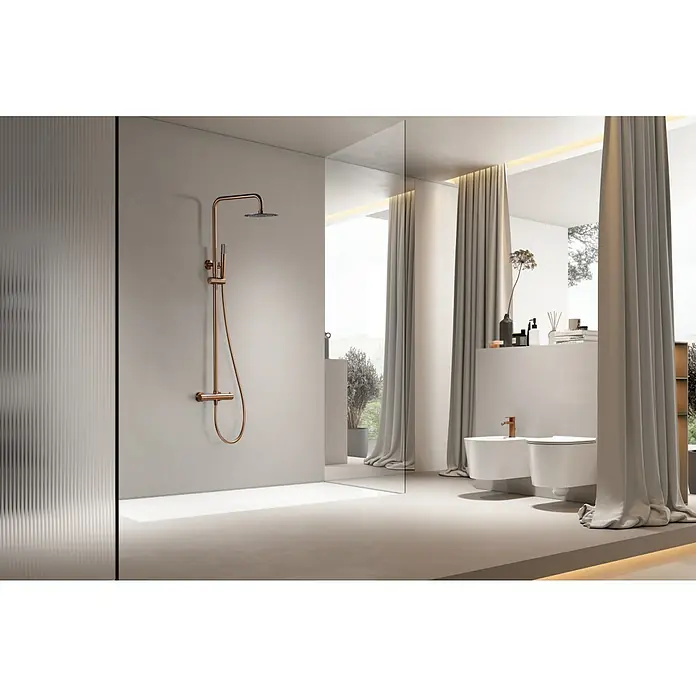 Imex Génova Sistema de ducha - Grifo termostático, Oro rosa - La imagen muestra una elegante grifería de baño con acabado de cobre montada en una pared lisa, acentuando el diseño moderno del baño.