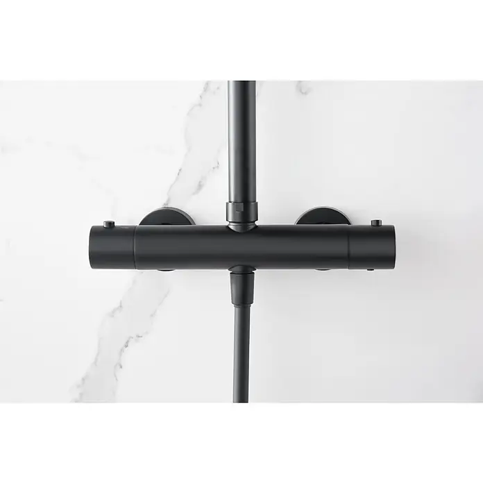 Imex Nápoles Sistema de ducha - Grifo termostático, Negro - Una foto detallada muestra una moderna grifería de ducha en negro mate sobre un fondo de mármol, destacando su diseño minimalista.