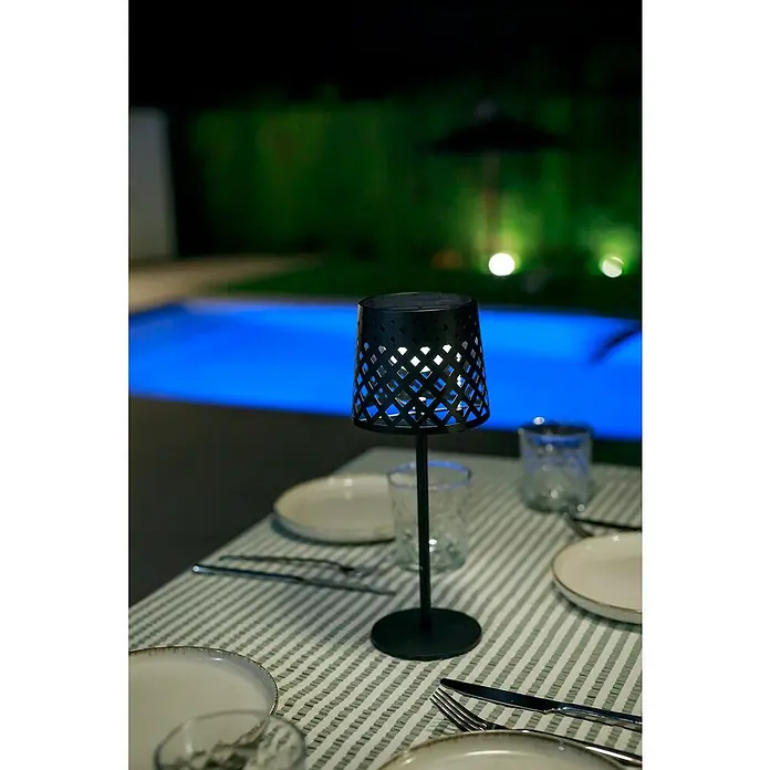 New Garden Lámpara de sobremesa solar Gretita - 1,5 W, Negro, Blanco cálido, IP44 - Elegante lámpara de mesa con pantalla de celosía. Está sobre una mesa puesta junto a la piscina y proporciona iluminación ambiental.