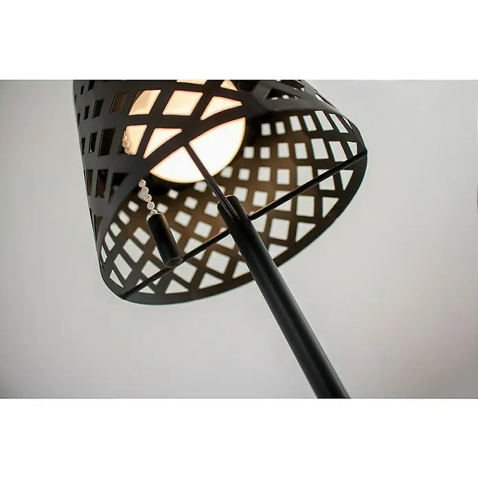 New Garden Lámpara de sobremesa solar Gretita - 1,5 W, Negro, Blanco cálido, IP44 - Primer plano de una lámpara de pie negra con una pantalla perforada que emite una luz cálida.