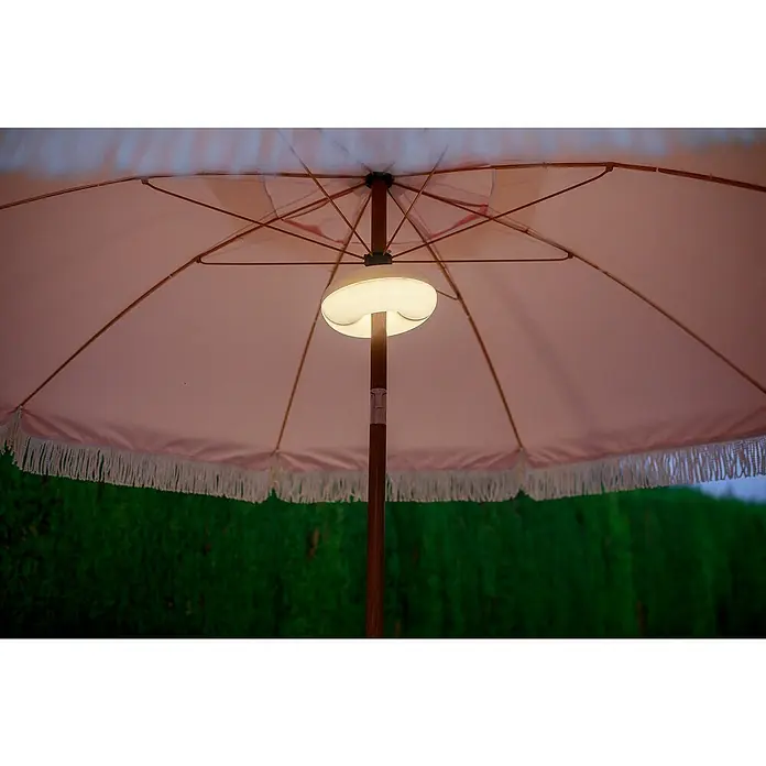 New Garden Plafón LED para parasol Lima - Ø x Al: 17,5 x 6,75 cm - Primer plano de una sombrilla de patio iluminada con un borde con flecos, creando un espacio exterior acogedor y elegante.