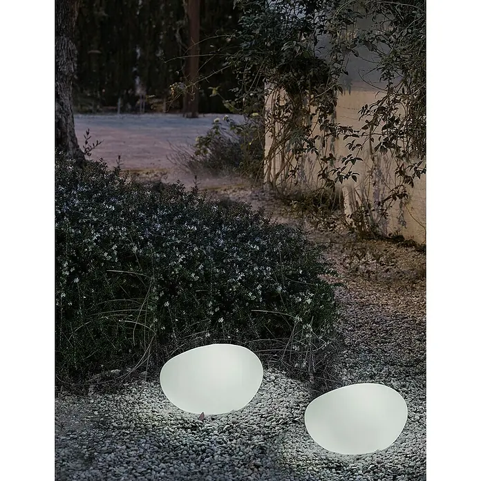 Starlux Bola solar Himero 60 - Altura: 30 cm, LED - Escena de jardín atmosférica con dos luces de jardín ovoides y brillantes sobre grava, creando una iluminación suave.