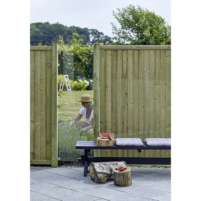 Plus Sichtschutzelement Futura Klar - 55,4 x 176 cm, Glas, Transparent - Diese Aufnahme zeigt einen grünen Gartenzaun mit einer Glaswand, der ein modernes und stilvolles Design für den Außenbereich bietet.