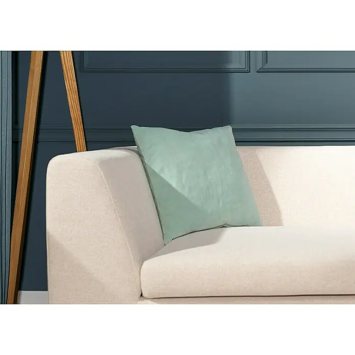 Kissen Velvet - Silt Green, 45 x 45 cm, 100 % Baumwolle - Ein mintgrünes Kissen auf einem eleganten, cremefarbenen Sofa vor einer stilvollen Wand.