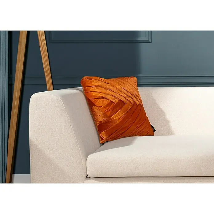 Kissen Folded - Rostrot, 45 x 45 cm, 100 % Baumwolle - Nahaufnahme eines rechteckigen, orangefarbenen Kissens mit dekorativen Falten auf einem cremefarbenen Sofa.
