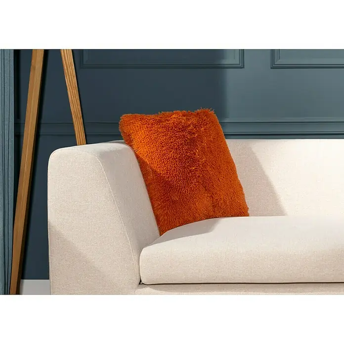 Kissen BodrumRostrot, 45 x 45 cm, 100 % Polyester - Nahaufnahme eines weißen Sofas mit einem orangefarbenen Kissen. Die Textur des Kissens ist weich und plüschig, was es zu einem Blickfang macht.