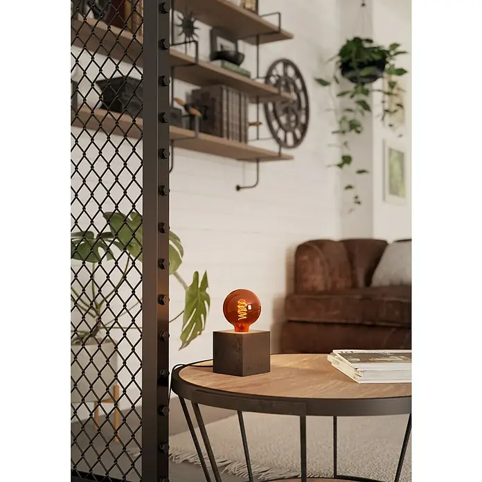 Eglo Bombilla LED - E27, Intensidad regulable, Blanco cálido, 30 lm, 4 W - Primer plano de una lámpara de mesa decorativa con bombilla naranja sobre una mesa de madera en la sala de estar.