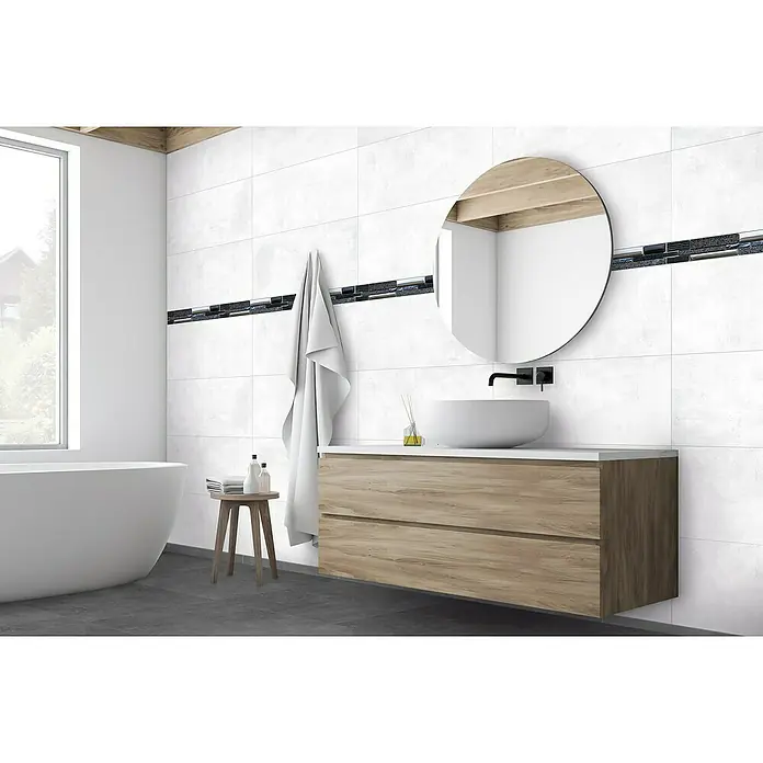 Wandfliese Casa - 29,7 x 59,7 cm, Grau, Matt - Ein Badezimmer mit weißen Wandfliesen, einem Holzunterschrank und einem runden Spiegel für ein elegantes Ambiente.