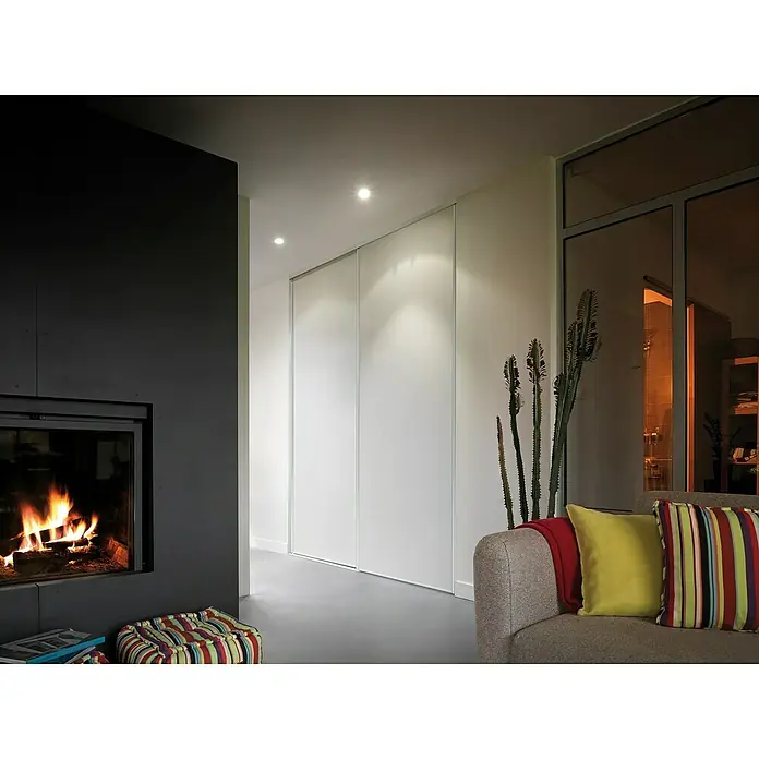 Optimum Schiebetür-Bau-Set - Weiß, 120 x 250 cm - Gemütliches Wohnzimmer mit Kamin, stilvollem Sofa mit Kissen und eleganten weißen Schiebetüren im Hintergrund, die eine moderne Atmosphäre schaffen.