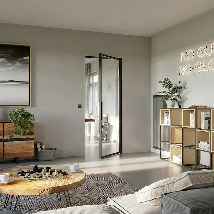 Room Plaza Loft + Mehr Drehtür-Komplettset - 750 x 2.130 mm, DIN Anschlag: Rechts, Klarglas - Moderner Wohnraum mit einem Glaspendeltürsystem, das den Raum optisch öffnet und für viel Licht sorgt. Möbel und Deko im Hintergrund.
