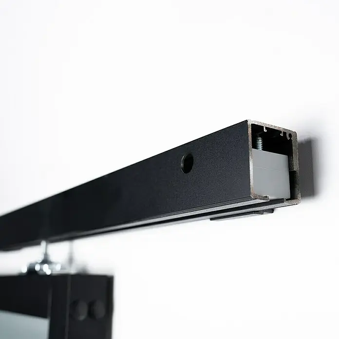 Room Plaza Loft + Mehr Schiebetür-Komplettset - 940 x 2.060 mm, Satiniertes Glas - Nahaufnahme einer schwarzen Schiene zur Befestigung von Beleuchtungskörpern an einer Wand.