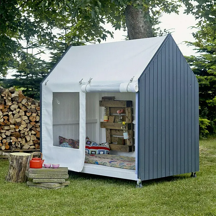 Plus Gewächshaus - Außenmaß inkl. Dachüberstand (B x T): 203 x 123 cm, 15 mm, Natur - Das Bild zeigt ein charmantes Spielhaus mit einem weißen Stoffdach und grauen Holzwänden, das zum Spielen im Garten einlädt.