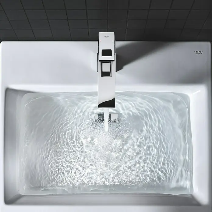 Grohe Eurocube Waschtischarmatur M-Size - Mit Zugstange, Chrom, Glänzend - Ein Waschbecken mit einem modernen Grohe Wasserhahn, aus dem Wasser fließt, das das Becken füllt.