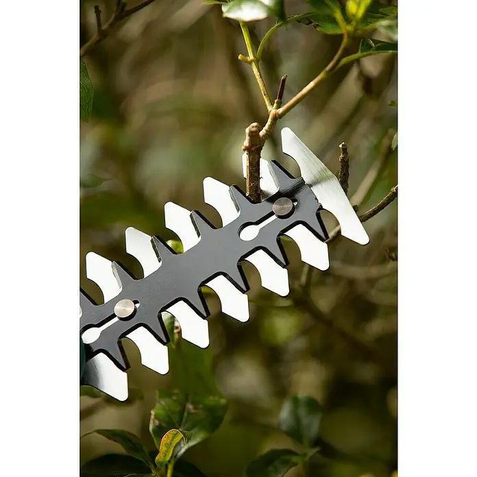 Bosch Akku-Gras- & Strauchschere Isio - 3,6 V, Li-Ionen, 1,5 Ah, 1 Akku, Schwertbreite: 8 cm, Akkulaufzeit: 50 min - Nahaufnahme einer Heckenschere beim Schneiden von Ästen, die scharfen Klingen sind deutlich sichtbar, ideal für die Gartenarbeit.