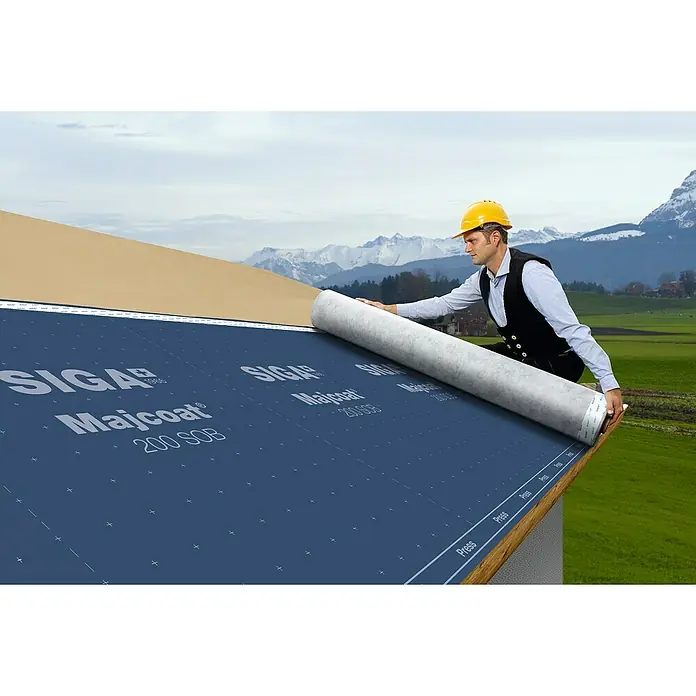 Siga Dachunterdeckbahn Majcoat 200 SOB - 20 m², 13,4 x 1,5 m, Polypropylen - Ein Dachdecker, der eine SIGA Majcoat 200 SOB Unterdeckbahn auf einem Dach mit einer malerischen Bergkulisse verlegt.