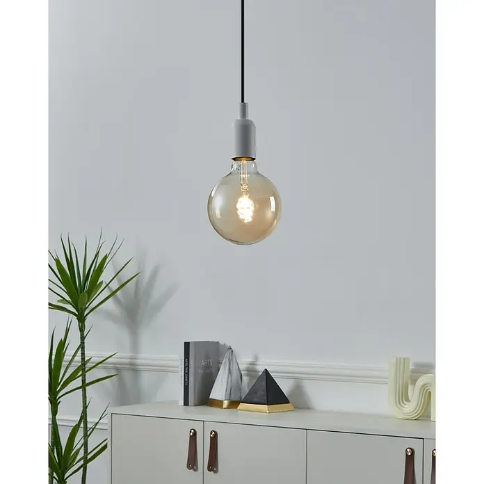 Eglo connect.z Smart-LED-Lampe - E27, Dimmbar, Warmweiß, 400 lm - Eine moderne Pendelleuchte mit einer bernsteinfarbenen Glühbirne, die ein warmes Licht in einem stilvollen Raum verbreitet.