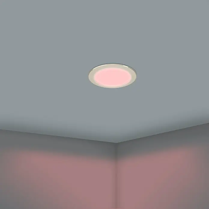 Eglo LED-Einbauleuchten-Set rund ABIUL - 3,2 W, Ø x H: 8,6 x 4 cm, Nickel, RGBW - Diese Nahaufnahme zeigt eine moderne runde Deckenleuchte mit rosafarbenem Licht in einem Raum mit grauen Wänden. Die Leuchte ist elegant und minimalistisch.