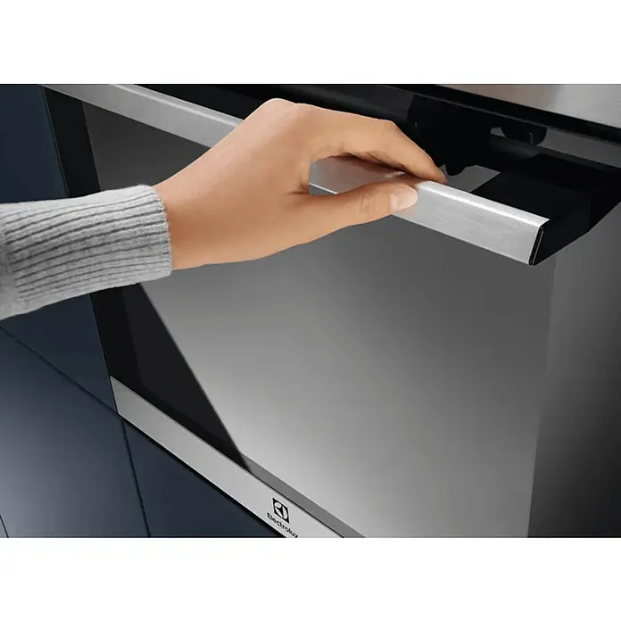 Electrolux Horno empotrado EOH4P56BX - Número de tipos de calentamiento: 9 ud., Volumen horno: 65 l - Primer plano de un horno Electrolux con una mano tocando el asa, destacando el diseño elegante y la función fácil de usar del horno.
