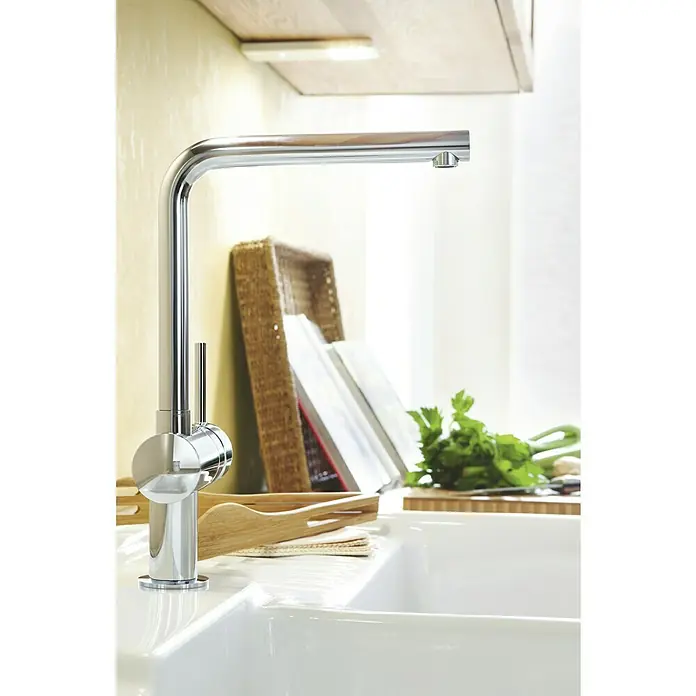 Grohe Spültischarmatur Minta - L-Auslauf, Chrom, Glänzend, Schwenkbar - Nahaufnahme einer modernen Spültischarmatur aus Chrom in einer hellen Küche mit Utensilien.