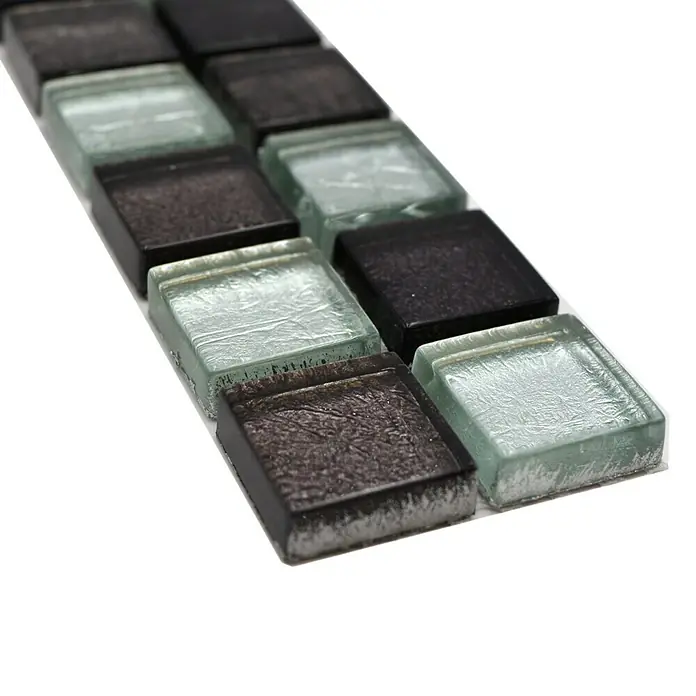 Fliesenbordüre Struktur YBO 8BS18 - 30 x 4,8 cm, Mix Silber/Schwarz, Glänzend - Nahaufnahme einer Reihe von quadratischen Mosaikfliesen in Schwarz und Blassblau, die ein elegantes und modernes Designelement zeigen.
