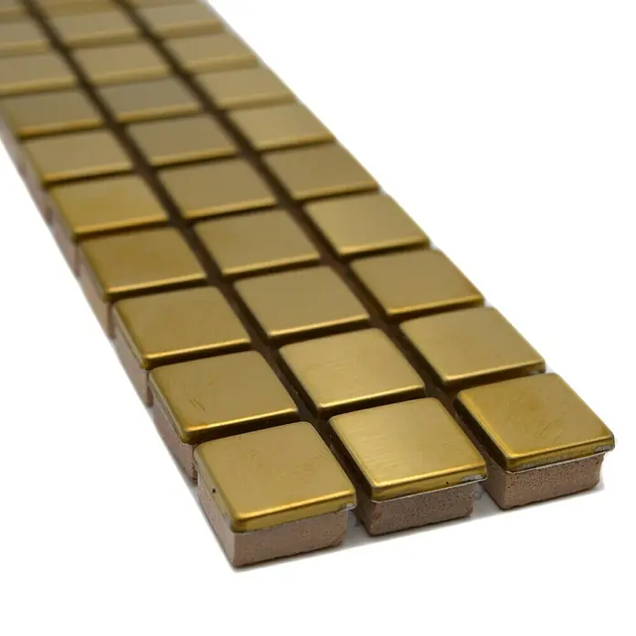 Fliesenbordüre Steel gestrichen YBO 15DG - 30 x 4,8 cm, Gold, Glänzend - Nahaufnahme von goldenen Mosaikfliesen auf einer weißen Oberfläche, die für Dekorationen und kreative Projekte geeignet sind.
