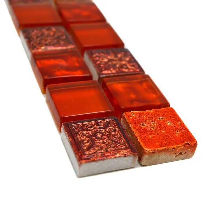 Fliesenbordüre YBO CB30 - 30 x 4,8 cm, Mix Rot, Glänzend - Nahaufnahme einer Reihe von orangefarbenen Mosaikfliesen mit verschiedenen Mustern, die sich perfekt für dekorative Projekte eignen.