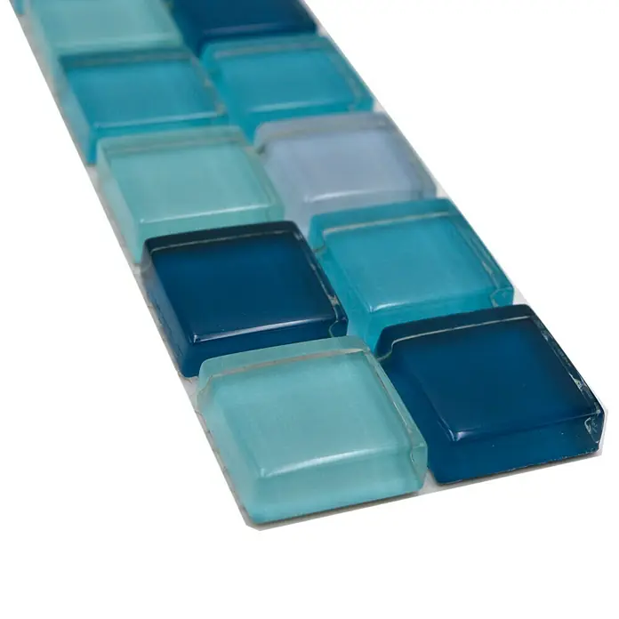 Fliesenbordüre YBO 8SE95 - 4,8 x 30 cm, Mix Blau/Petrol, Glänzend - Nahaufnahme von blauen und türkisfarbenen Glasmosaikfliesen, ideal für Küchenrückwände oder Badezimmerakzente. Ihre glänzende Oberfläche verleiht jedem Raum einen Hauch von Eleganz.