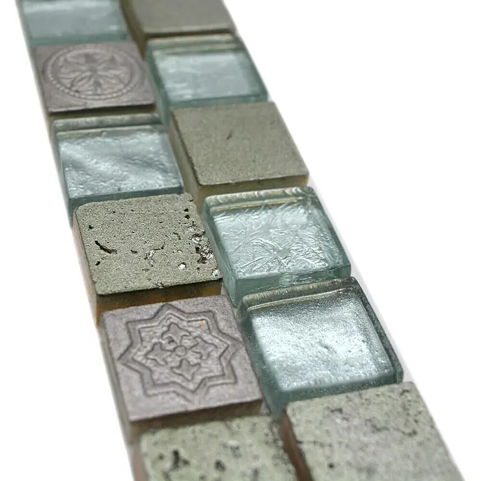 Fliesenbordüre YBO CB33 - 30 x 4,8 cm, Mix Silber, Glänzend - Nahaufnahme von quadratischen Mosaikfliesen in Grau und Blau mit verschiedenen Texturen und Designs.