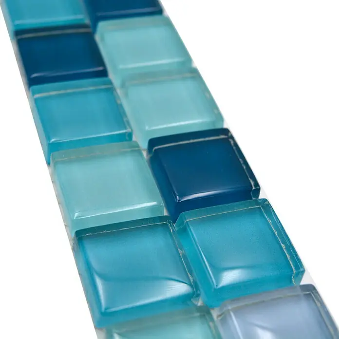 Fliesenbordüre YBO 8SE95 - 4,8 x 30 cm, Mix Blau/Petrol, Glänzend - Detailaufnahme einer Reihe schimmernder blauer Glasmosaikfliesen, ideal für stilvolle Wand- und Bodengestaltungen.