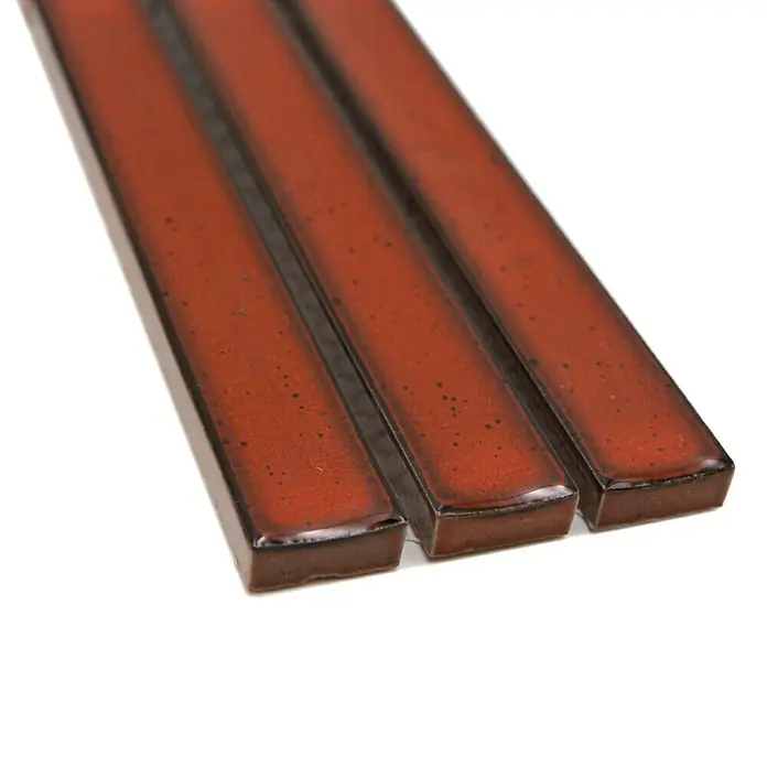 Fliesenbordüre YBO CS56 - 6,9 x 29,6 cm, Rot, Glänzend - Nahaufnahme von drei dunkelrot glasierten Keramik-Stäbchen mit einer leicht unregelmäßigen Oberfläche.