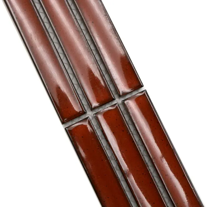 Fliesenbordüre YBO CS56 - 6,9 x 29,6 cm, Rot, Glänzend - Nahaufnahme von länglichen, braunen Fliesen mit glänzender Oberfläche und dunklen Akzenten, die ein elegantes Design zeigen.