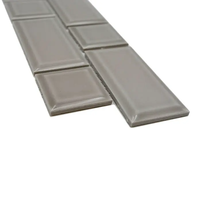 Fliesenbordüre Uni YBO M04CM - 4,5 x 29,4 cm, Grau, Glänzend - Nahaufnahme von grauen, glänzenden Keramikfliesen in verschiedenen Formen auf weißem Untergrund.