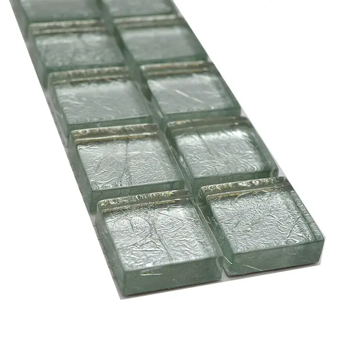 Fliesenbordüre Struktur YBO 8SB16 - 30 x 4,8 cm, Silber, Glänzend - Nahaufnahme einer Reihe von quadratischen Mosaikfliesen mit einer silbernen, rissartigen Textur, die ein modernes und stilvolles Design zeigen.