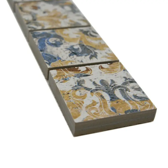 Fliesenbordüre Vestige YBO CV47MSC - 29,5 x 4,7 cm, Bunt, Matt - Ein detailliertes Bild von dekorativen Fliesen mit einem klassischen, floralen Muster in Gold und Blau, ideal für stilvolle Innenräume.