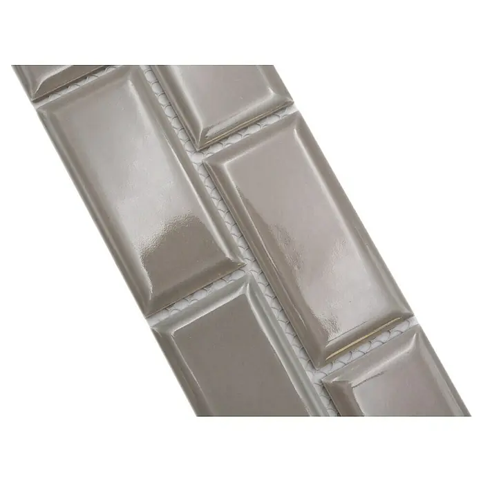 Fliesenbordüre YBO M03C - 4,5 x 29,5 cm, Grau, Glänzend - Nahaufnahme einer grauen, glänzenden, rechteckigen Wandfliese imitiert Ziegeloptik, ideal für moderne Küchen- oder Badezimmerdesigns.