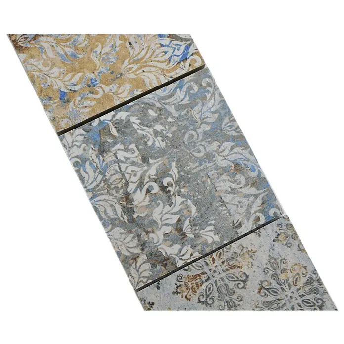 Fliesenbordüre Vestige YBO CV95MSC - 29 x 9,5 cm, Bunt, Matt - Nahaufnahme von drei dekorativen Keramikfliesen mit aufwendigen floralen Mustern in Beige, Grau und Blau.
