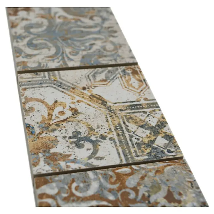Fliesenbordüre Vestige YBO CV71MSC - 29 x 7,1 cm, Bunt, Matt - Nahaufnahme von drei dekorativen Keramikfliesen mit einem komplexen Muster in Beige-, Blau- und Brauntönen, ideal für stilvolle Wand- und Bodengestaltung.
