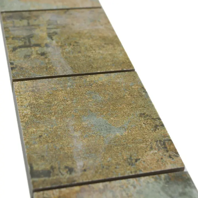 Fliesenbordüre YBO CB71BBG29 x 7,1 cm, Mix Beige/Braun/Grün, Matt - Nahaufnahme von quadratischen Mosaikfliesen mit einer einzigartigen, verwitterten Optik in Gold- und Grüntönen.