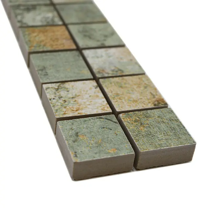 Fliesenbordüre YBO CB25BBG - 29,5 x 5,2 cm, Mix Beige/Braun/Grün, Matt - Nahaufnahme einer Reihe von quadratischen Mosaikfliesen mit grün-bräunlicher Marmorierung, ideal für Bad und Küche.