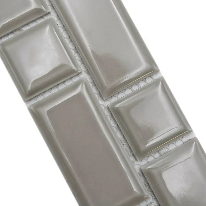 Fliesenbordüre Uni YBO M04CM - 4,5 x 29,4 cm, Grau, Glänzend - Nahaufnahme von grauen, rechteckigen und quadratischen Wandfliesen mit glänzender Oberfläche und abgerundeten Kanten.
